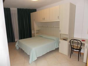 1 dormitorio pequeño con 1 cama y 1 silla en Hotel Colorado en Lido di Jesolo