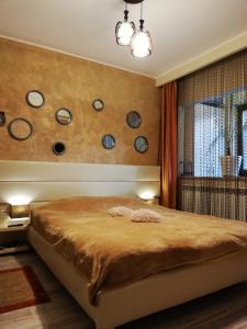 a bedroom with a bed with plates on the wall at Tomis Apartament in Constanţa