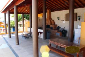 une grande terrasse avec des tables et une cheminée dans une maison dans l'établissement Chalé Recanto Monte Sinai, à Piracaia