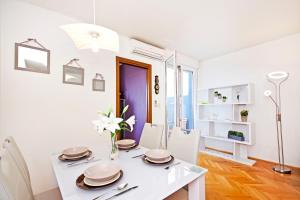 a white dining room with a white table and chairs at Apartment Joker in Split