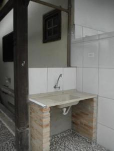 a bathroom with a sink on a wall at Alebelhinha Residencial Camburi Pousada in Camburi