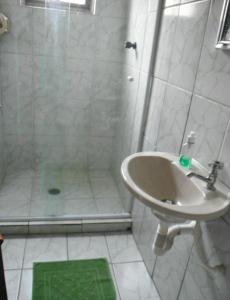 a bathroom with a shower and a sink at Alebelhinha Residencial Camburi Pousada in Camburi