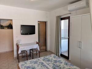 sypialnia ze stołem i telewizorem na ścianie w obiekcie Rooms & Apartments Hegic w mieście Zadar