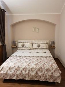 um quarto com uma cama grande e um edredão branco em La casa del gnocco em Masone