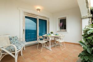 een patio met een tafel en stoelen en een raam bij Apartment in S'Abba e Sa Pedra complex with pool in Golfo Aranci +17 foto's