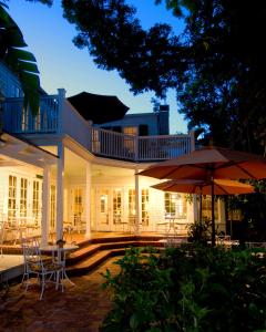 a large white house with tables and chairs at The Gardens Hotel in Key West