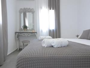 a white bedroom with a bed with towels on it at Bonatsa House in Agios Georgios