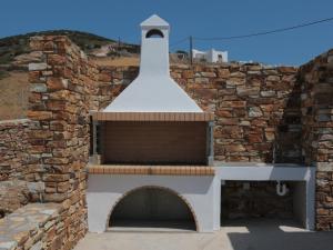 a brick wall with a chimney on top of a building at Bonatsa House in Agios Georgios