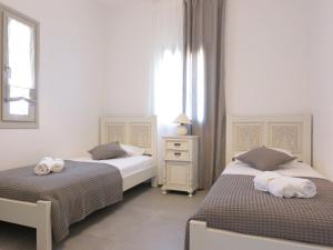 a bedroom with two beds and a window at Bonatsa House in Agios Georgios