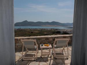 two chairs and a table with fruit on a balcony at Bonatsa House in Agios Georgios