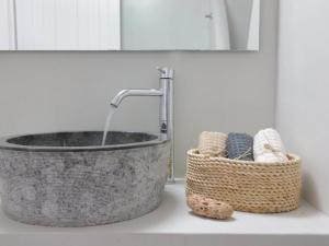 a bathroom sink with a basket and a tub at Bonatsa House in Agios Georgios