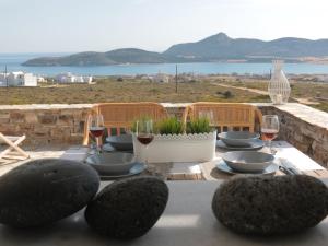 a table with glasses of wine and some rocks at Bonatsa House in Agios Georgios