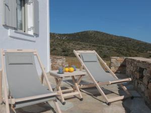 two chairs and a table with oranges on a balcony at Bonatsa House in Agios Georgios