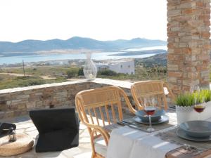 a table and chairs on a patio with a view of the ocean at Bonatsa House in Agios Georgios
