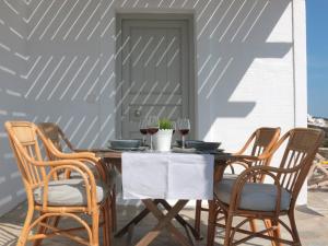 a wooden table with four chairs and wine glasses at Bonatsa House in Agios Georgios +24 photos