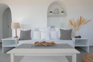 a white living room with a couch and a table at Bonatsa House in Agios Georgios