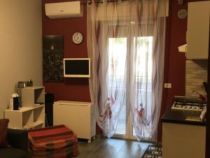 a kitchen with a sliding glass door with curtains at Casa di Ema in Sanremo