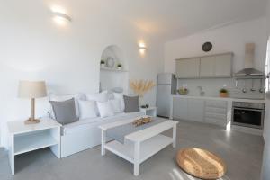 a living room with a white couch and a kitchen at Bonatsa House in Agios Georgios