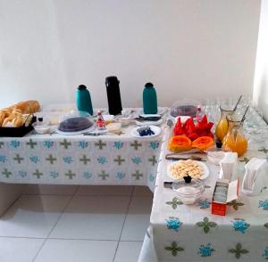 una mesa con un mantel blanco con comida. en Pousada Oluap en Mairiporã
