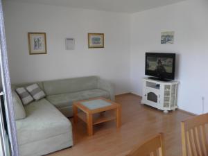 uma sala de estar com um sofá e uma televisão em Apartment Adria em Trogir