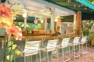 a row of white chairs in front of a bar at The Gardens Hotel in Key West