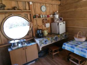 a kitchen with a refrigerator and a table in a cabin at Kadariku Tourism Farm in Sakla