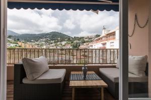 a balcony with a table and chairs and a view of a city at Beautiful Apartment near Monaco in Roquebrune-Cap-Martin