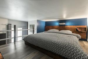 ein Schlafzimmer mit einem großen Bett mit einer blauen Wand in der Unterkunft Mezzanine Studio near Monaco in Roquebrune-Cap-Martin