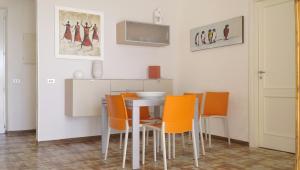 a dining room with a table and orange chairs at Villa a Diamante Sulla Spiaggia in Belvedere Marittimo