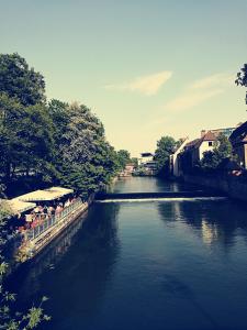 Ein Fluss mit einer Gruppe von Menschen, die auf einer Brücke sitzen in der Unterkunft Ferien - und Messewohnung am Wöhrder See in Nürnberg