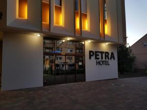 a hotel with a sign in front of a building at Petra Hotel in Nyíregyháza
