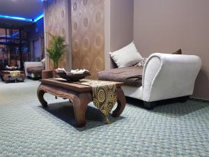 sala de estar con sofá y mesa de centro en Petra Hotel en Nyíregyháza