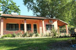 a small orange house with a grass yard at Villa Magia in Ipsos