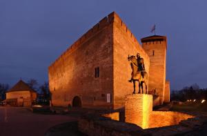 a statue of a man riding a horse in front of a building at D-Hotel in Gyula