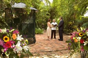 a group of people standing in a garden with flowers at The Gardens Hotel in Key West