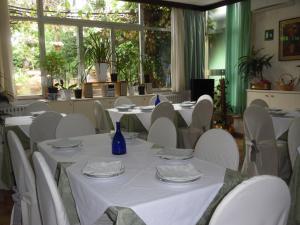 a dining room with white tables and white chairs at Albergo Livorno in Casciana Terme