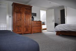 a bedroom with a wooden dresser and a bed at Rooms36 in Keswick