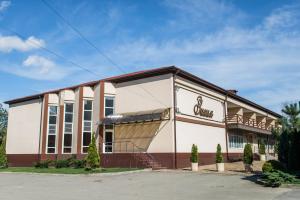 a building with a sign on the front of it at Zihia Hotel in Maykop