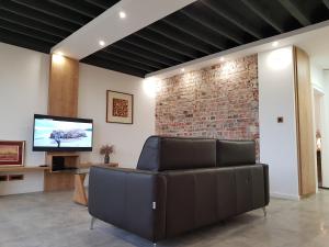 a living room with a couch and a brick wall at Harbour Apartment sea view in Zadar