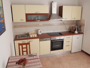 a small kitchen with white cabinets and a sink at Beachfront Apartment Jelsa in Jelsa