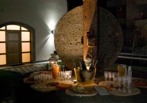 una mesa con platos de comida y vasos. en B&B Le Antiche Cisterne, en Tremestieri Etneo