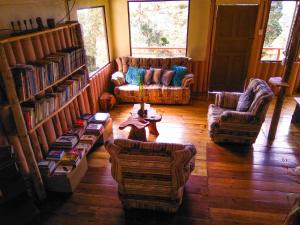 een woonkamer met banken en een tafel en boekenplanken bij Iyok Ami (Madre Tierra) in Cartago