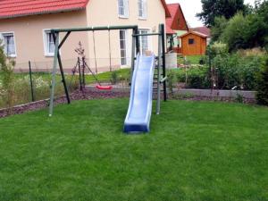 a playground with a slide in a yard at Ferienwohnungen Schlossblick in Muhr amSee