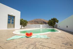 Elixirium villa في بيريسا: شريحة من البطيخ موضوعة على الأرض بجوار حمام سباحة