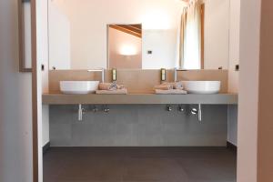 a bathroom with two sinks and two mirrors at Agritur Casteller in Trento