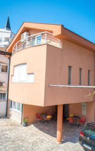 a building with a balcony and tables and chairs at Guesthouse Stari Grad in Mostar