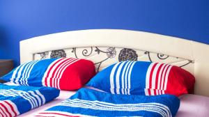 two pillows on a bed with a blue wall at Guesthouse Stari Grad in Mostar