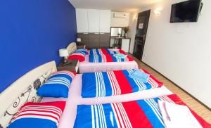 three beds in a room with a blue wall at Guesthouse Stari Grad in Mostar