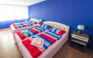 two beds in a room with blue walls at Guesthouse Stari Grad in Mostar