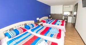 two beds in a room with a blue wall at Guesthouse Stari Grad in Mostar